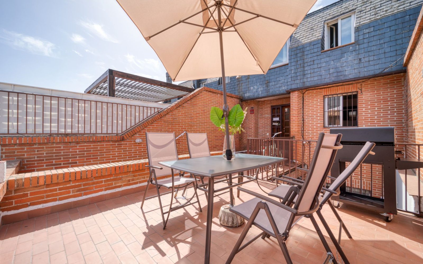 Terrasse mit Fliesenbelag in Terrakotta und Sitzgruppe